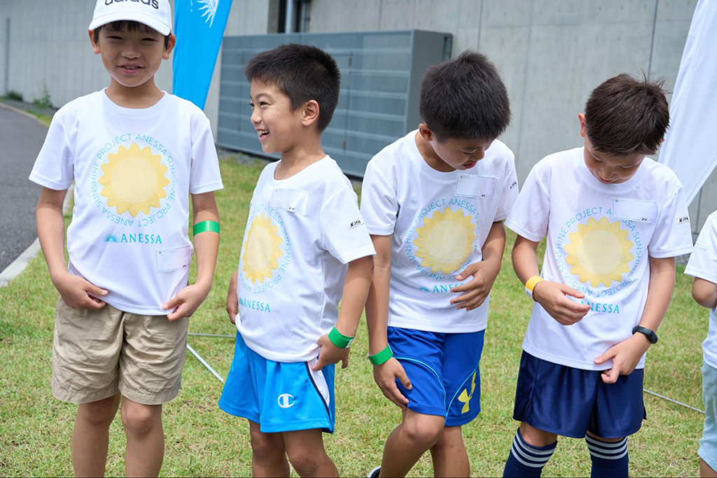 UV-Tシャツの胸の部分に紫外線が当たるとひまわりが浮かび上がり、驚く子どもたち。