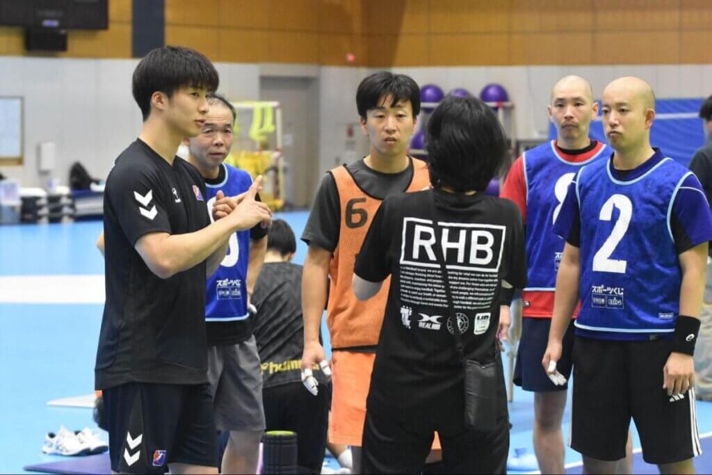 石田知輝(写真左)は手話通訳を交えながら、ライトウイングからの飛び込み方を教えていた