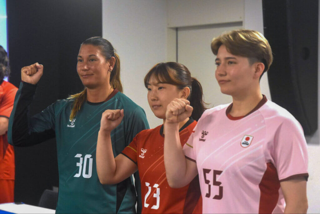 亀谷が着用するGKユニフォームは、常盤緑がベース。相澤が着用するファーストユニフォームは、男女共通の朱色。グレイ クレア フランシスが着用するセカンドユニフォームは、日本を象徴する桜色=2026年7月、ナショナルトレーニングセンターで(久保写す、以下すべて)